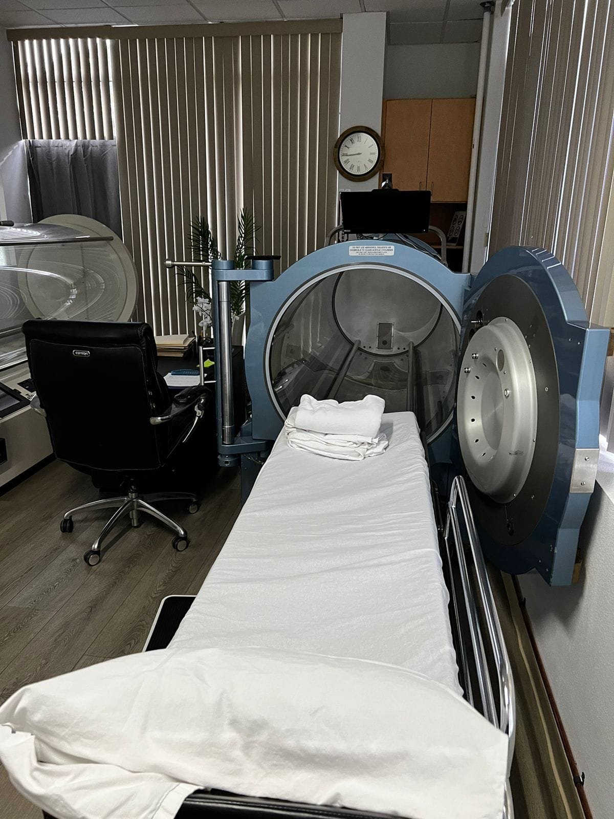 Medical-grade hyperbaric chamber at Pacific Hyperbarics — Oceanside, with open chamber and patient bed in our treatment room